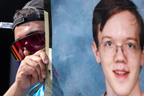 Homem segura placa com a foto de Thomas Matthew Crooks, jovem de 20 anos que tentou assassinar o ex-presidente Donald Trump durante um comício eleitoral na Pensilvânia. 17/07/2024