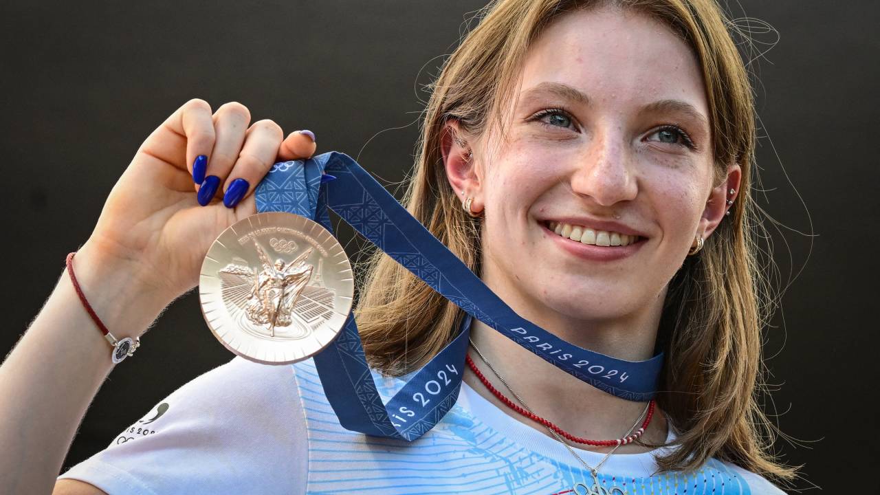 Romanian gymnast Ana Maria Barbosu poses with her Olympic bronze medal she was given on August 16, 2024 in Bucharest, Romania, after a gymnast from the US was stripped of it. Barbosu was awarded the Olympic floor exercise bronze medal originally given to Jordan Chiles, following a decision by the International Olympic Committee (IOC). The IOC decision followed a Court of Arbitration for Sport (CAS) ruling which cancelled the re-evaluation of Chiles' score on the grounds that the appeal of her degree of difficulty was lodged by the US team four seconds after the regulatory deadline, set at one minute. (Photo by Daniel MIHAILESCU / AFP)