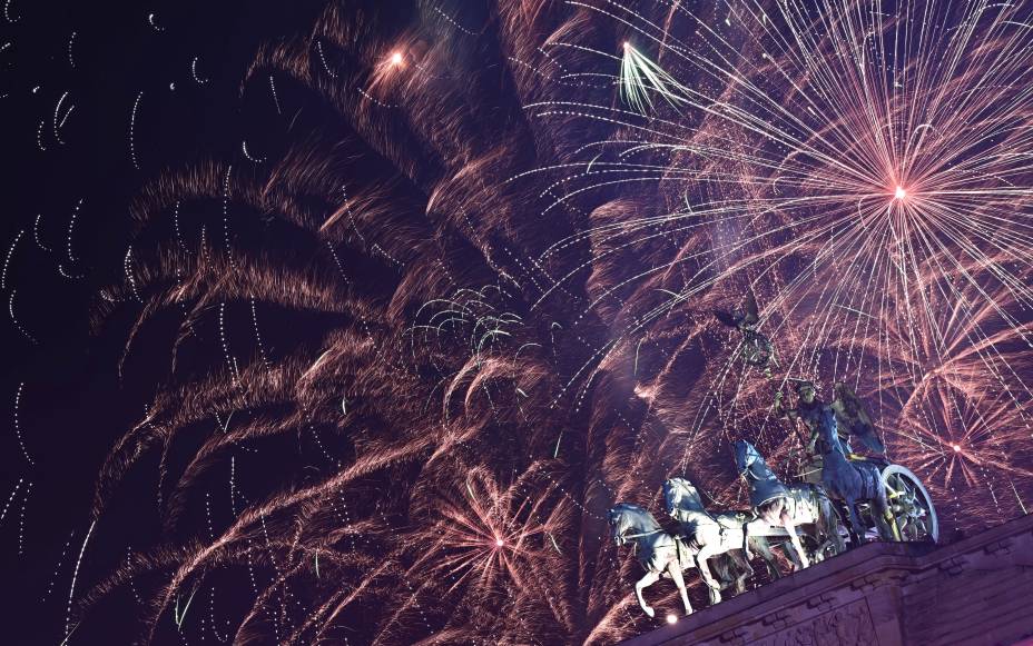Fogos de artifício iluminam a Quadriga no topo do Portão de Brandemburgo durante as celebrações do Ano Novo em Berlim, na Alemanha