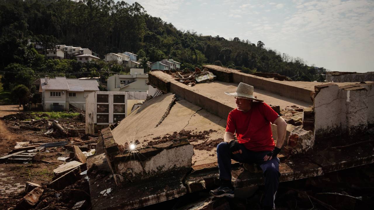 MUÇUM,RS, BRASIL - 01/08/2024 - Reportagem conta como está a reconstrução na pacata cidade no Vale do Taquari, que ficou conhecida depois que inúmeras enchentes, desde setembro de 2023, destruíram parte da cidade. Na foto, o morador Jairo Marobino sentado no que restou do Cemitério Municipal, levado pela correnteza do Rio Taquari. (FOTO: Carlos Macedo/Veja).