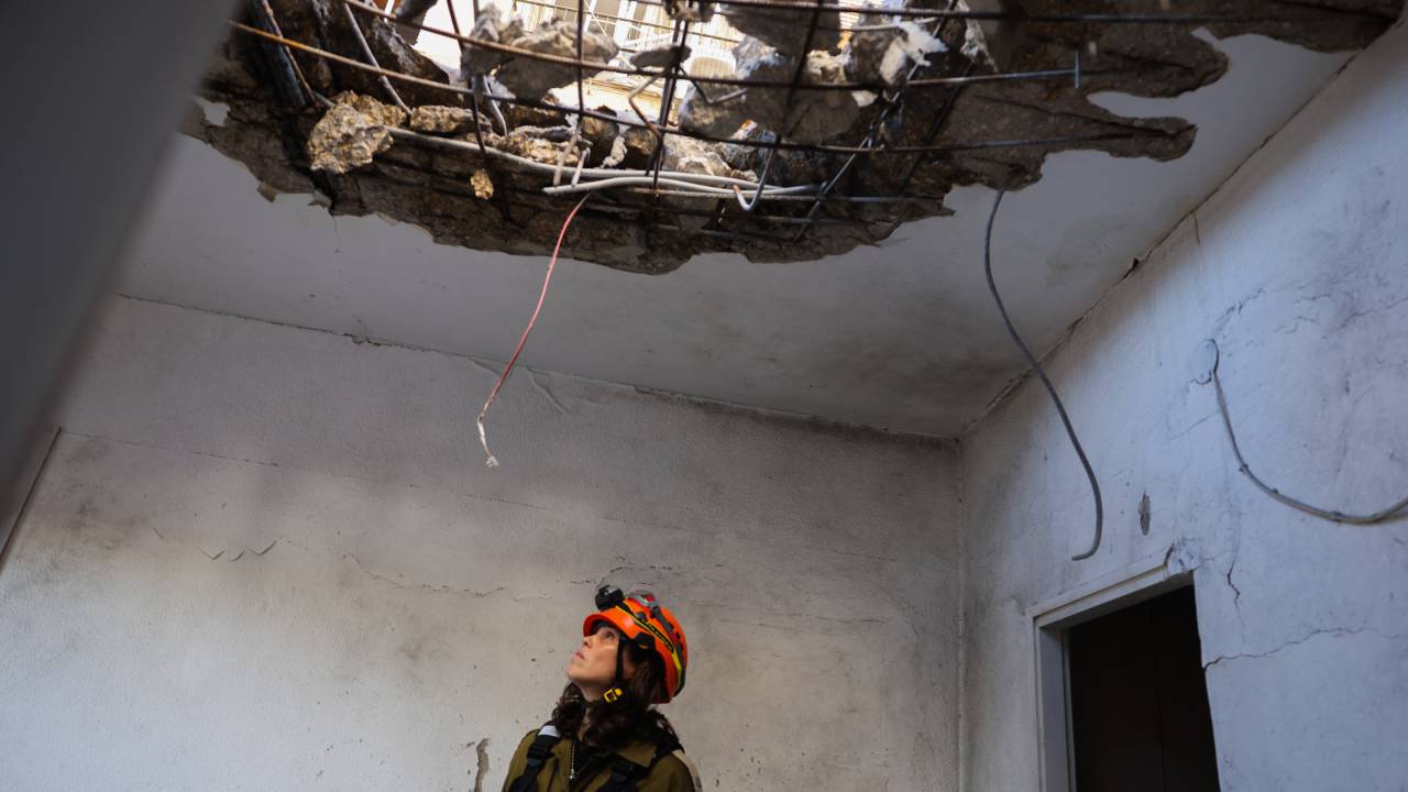 Um membro dos serviços de emergência israelenses inspeciona um prédio que foi atingido por um foguete lançado do Líbano, em Kiryat Yam, no norte de Israel. 08/10/2024