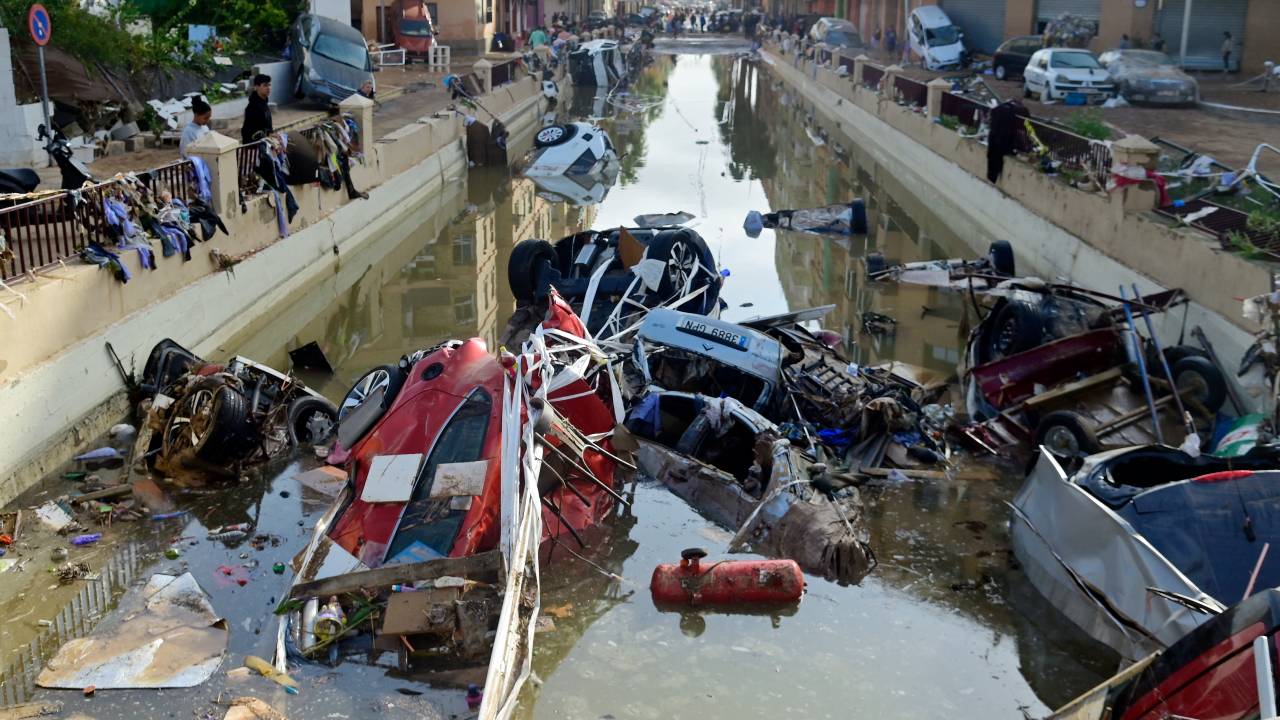 Wreckage of cars remain submerged in the water on October 31, 2024 after flash floods affected the town of Alfafar, in the region of Valencia, eastern Spain. Rescuers raced on October 31, 2024 to find survivors and victims of once-in-a-generation floods in Spain that killed at least 95 people and left towns submerged in a muddy deluge with overturned cars scattered in the streets. About 1,000 troops joined police and firefighters in the grim search for bodies in the Valencia region as Spain started three days of mourning. Up to a year's rain fell in a few hours on the eastern city of Valencia and surrounding region on October 29 sending torrents of water and mud through towns and cities. (Photo by JOSE JORDAN / AFP)