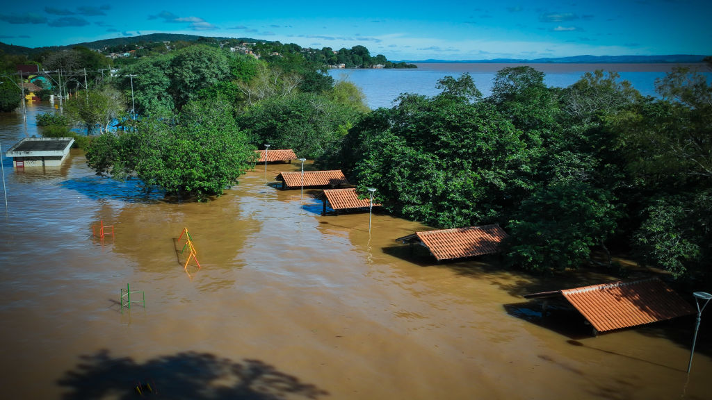 PORTO ALEGRE, BRAZIL - MAY 14: Aerial view of flooded houses of the Guarujá neighborhood, located in the extreme south of Porto Alegre, on May 14, 2024 in Porto Alegre, Brazil. After several days of heavy rain, Porto Alegre and many other municipalities in Rio Grande Do Sul are flooded due to the swelling of the rivers. Governor of the State, Eduardo Leite, issued an alert on the possible increase in the water level of Guaiba River that could elevate 20cm over the one reached last week which could be a historical register. (Photo by Jefferson Bernardes/Getty Images)