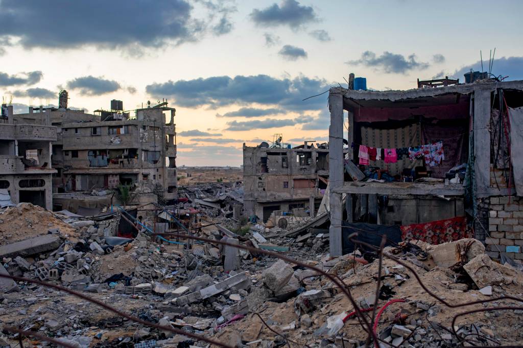 Palestinians in Khan Younis TERRA ARRASADA - Prédios destruídos na Faixa de Gaza: um ano de bombardeios e tiros que já mataram mais de 41 000