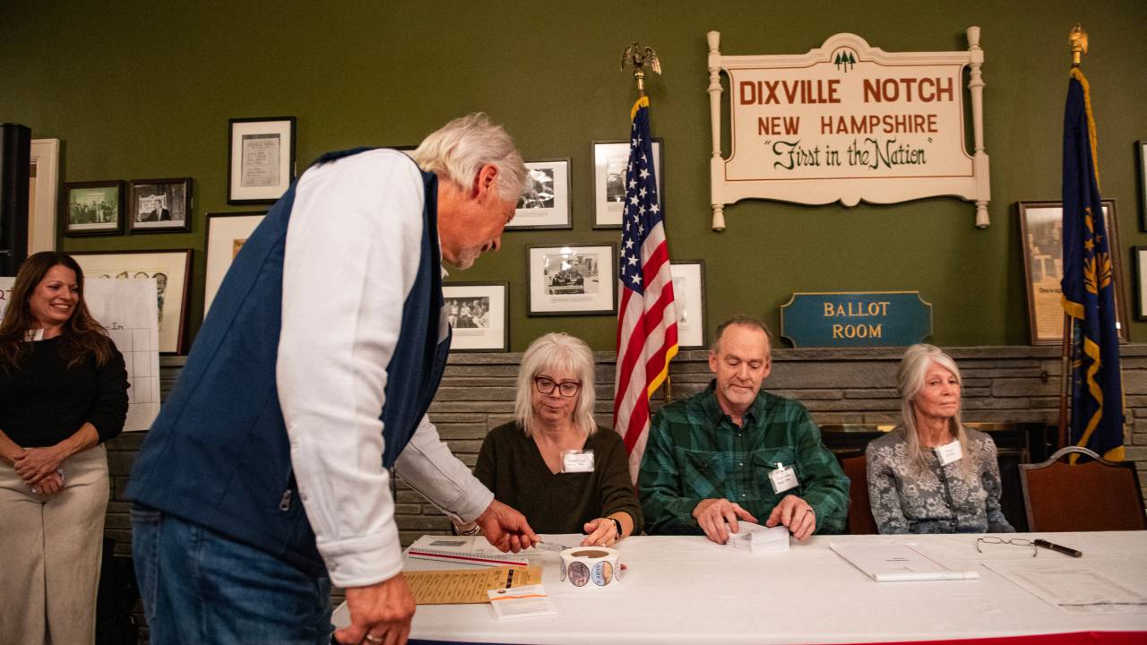 Um morador de Dixville Notch mostra sua identidade ao fazer o check-in para votar na eleição dos EUA à meia-noite de 5 de novembro