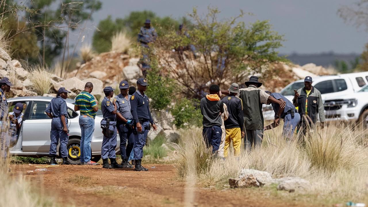 Familiares dos mineradores ilegais presos aguardam do lado de fora da mina em Stilfontein, na África do Sul. 13/11/2024