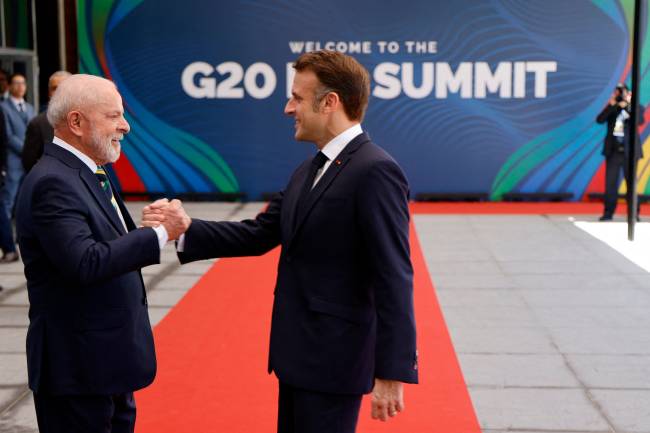 BRAZIL-G20-SUMMIT Brazil's President Luiz Inacio Lula da Silva (L) shakes hands with France's President Emmanuel Macron upon his arrival for the first day of the G20 Summit in Rio de Janeiro, Brazil, on November 18, 2024. (Photo by Ludovic MARIN / AFP)