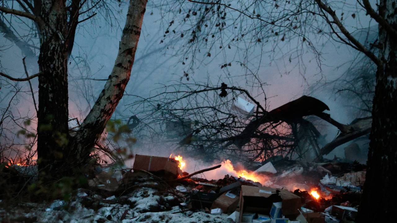 This photograph taken on November 25, 2024 shows burning goods following the crash of a cargo plane near the Vilnius International Airport in Vilnius. A cargo plane flying from Germany to Lithuania crashed early on November 25, 2024 near the airport of the capital Vilnius killing one person, firefighters said. (Photo by Petras MALUKAS / AFP)