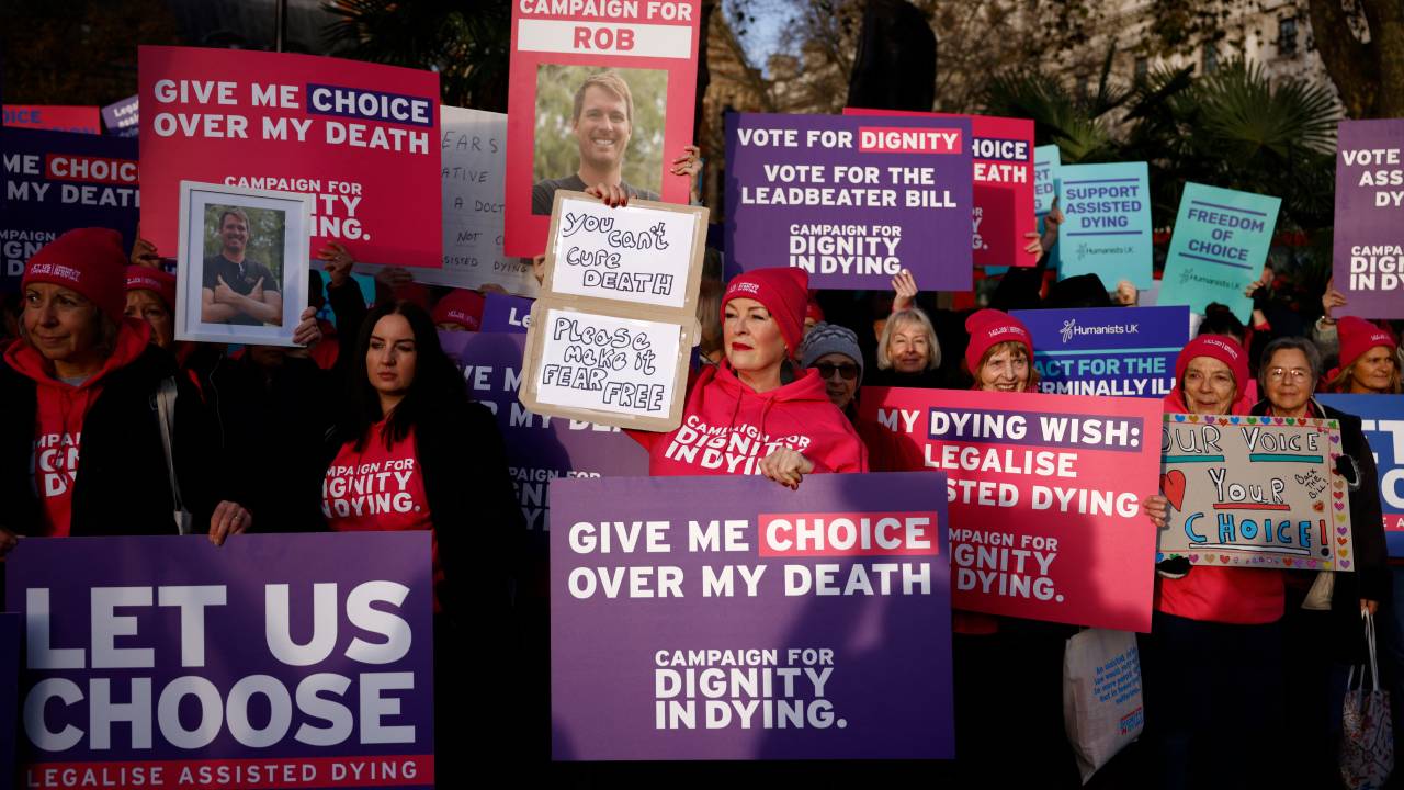 Campaigners supporting the assisted suicide bill hold placards at a demonstration outside The Palace of Westminster in central London, on November 29, 2024, as supporters and opponents of a bill to legalise euthanasia in the UK gather outside the Houses of Parliament while lawmakers debate the bill. UK lawmakers will debate vote today, on whether to advance divisive and emotive legislation to allow assisted dying for terminally ill people in England and Wales. (Photo by BENJAMIN CREMEL / AFP)