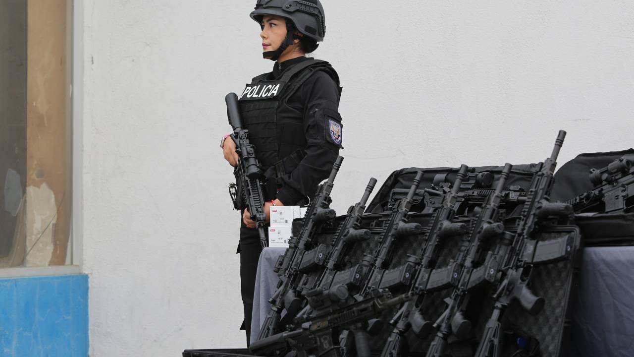Policial monta guarda durante um evento para fornecer rifles às forças armadas em Duran, no Equador. 06/08/2024