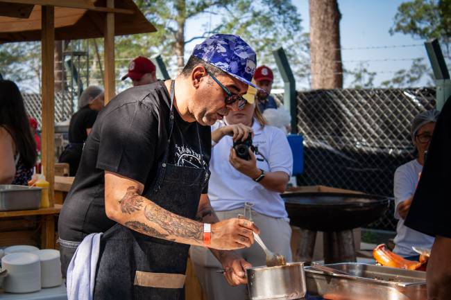 Jefferson Rueda finaliza os pratos que serão servidos durante a Festa do Porco