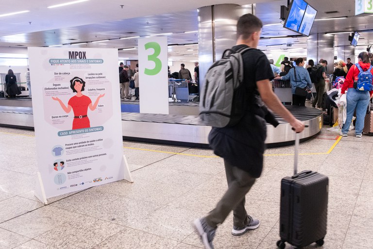 ALERTA: Painel na área de desembarque internacional do aeroporto de Brasília informa sobre sintomas da Mpox