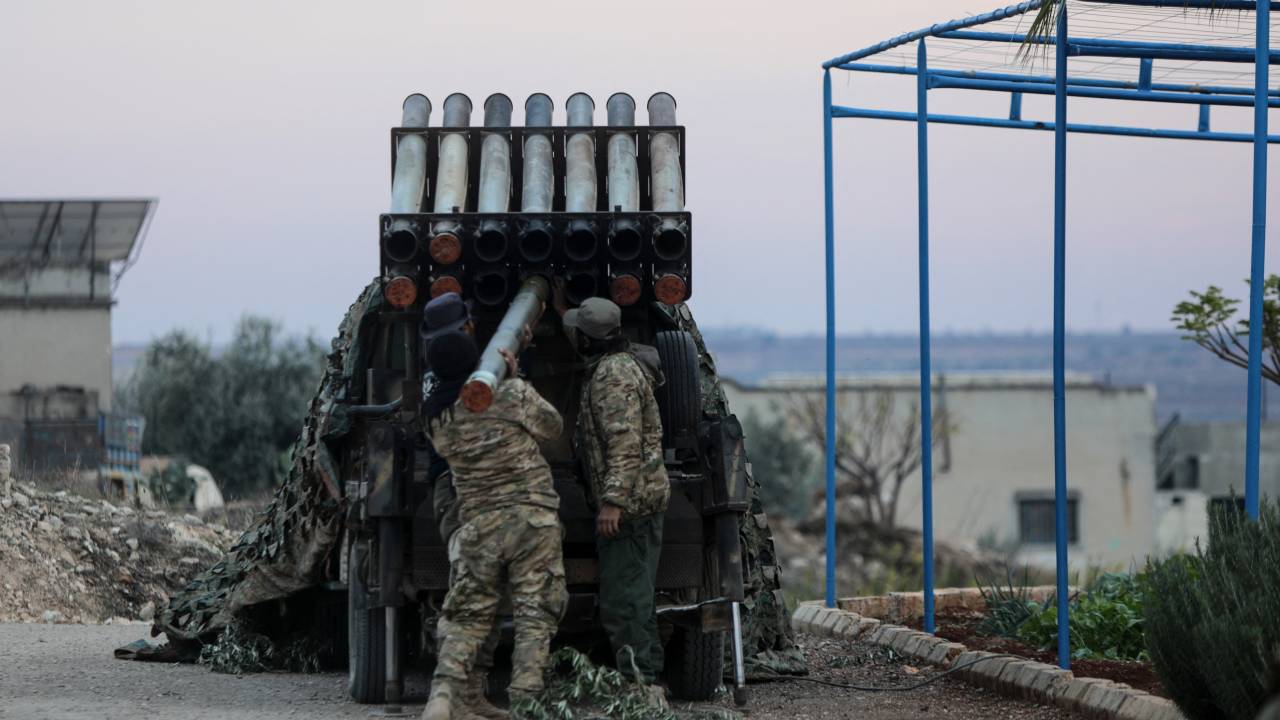 Anti-government fighters load a multi-barrel rocket launcher before firing against regime forces, in the northern outskirts of Syria's west-central city of Hama on December 4, 2024. Syrian government forces pressed a counterattack against Islamist-led rebels around the key city of Hama on December 4 after suffering a string of staggering losses further north, a war monitor said. (Photo by Bakr AL KASSEM / AFP)