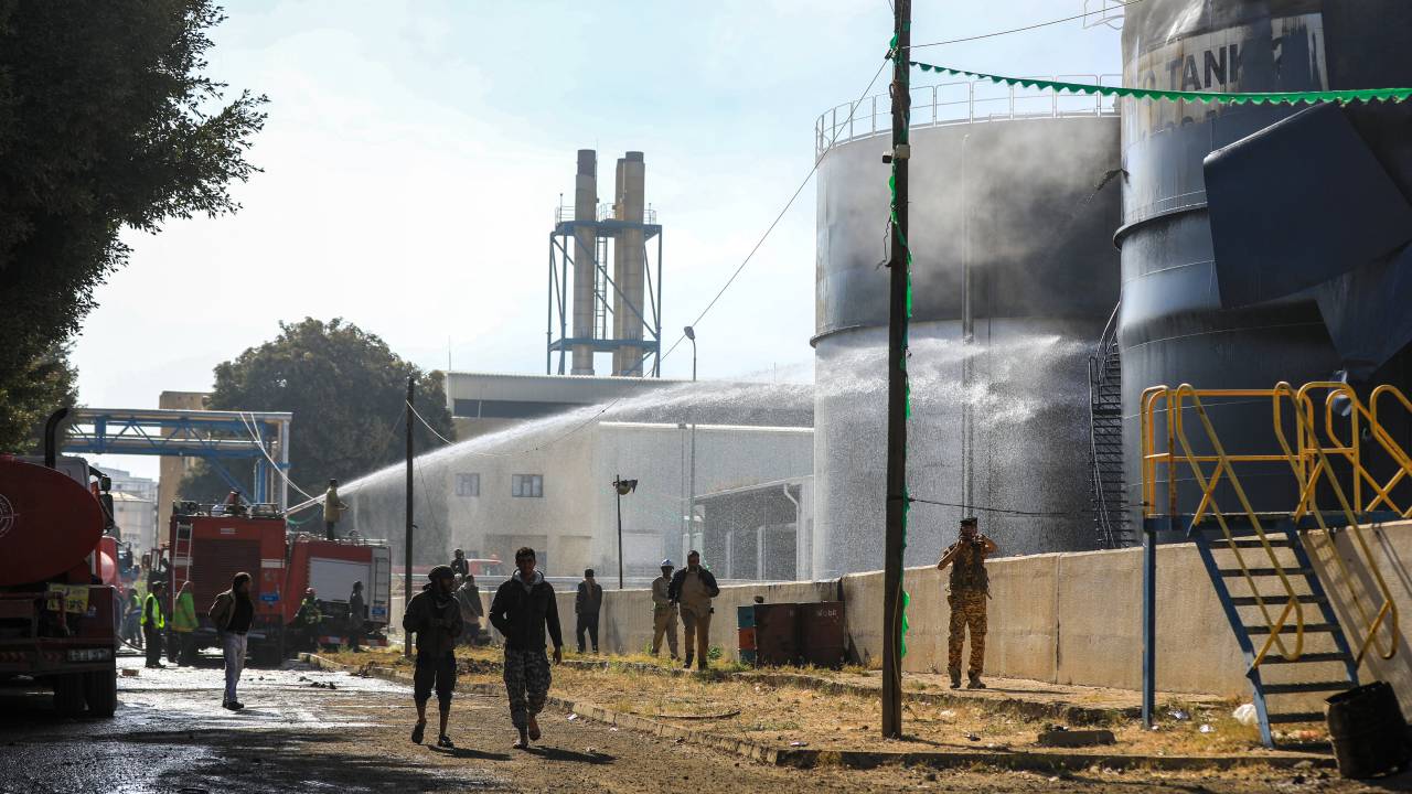 Bombeiros iemenitas jogam água em tanques de óleo em uma usina de energia atingida por um ataque aéreo israelense na capital Sanaa. 19/12/2024
