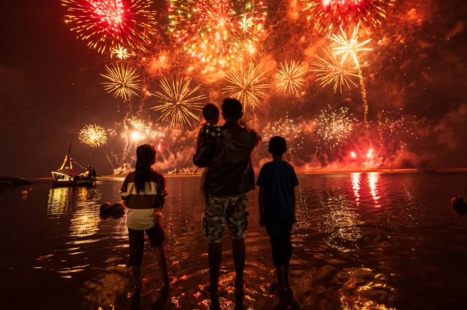 Família observa fogos na praia de Ancol, em Jacarta, Indonésia -