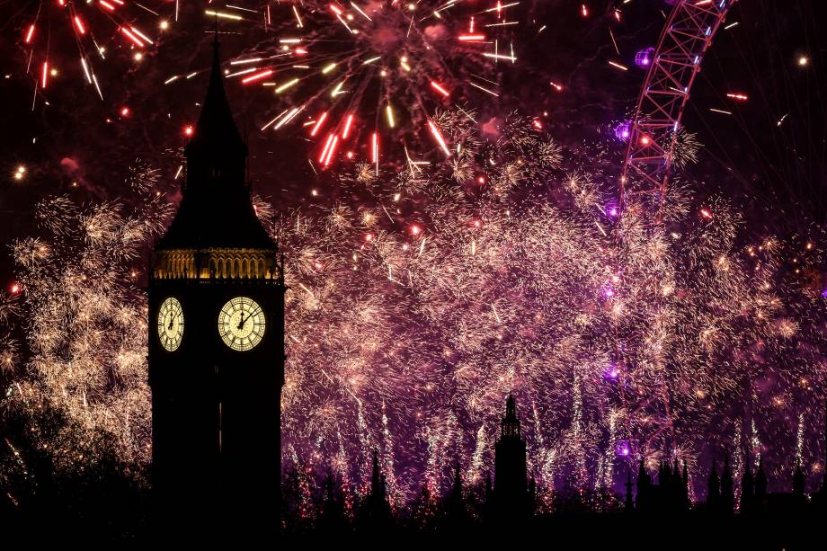 Fogos de artifício explodem no céu ao redor do London Eye e da Elizabeth Tower, comumente conhecida pelo nome do sino do relógio, Big Ben, no Palácio de Westminster, em Londres