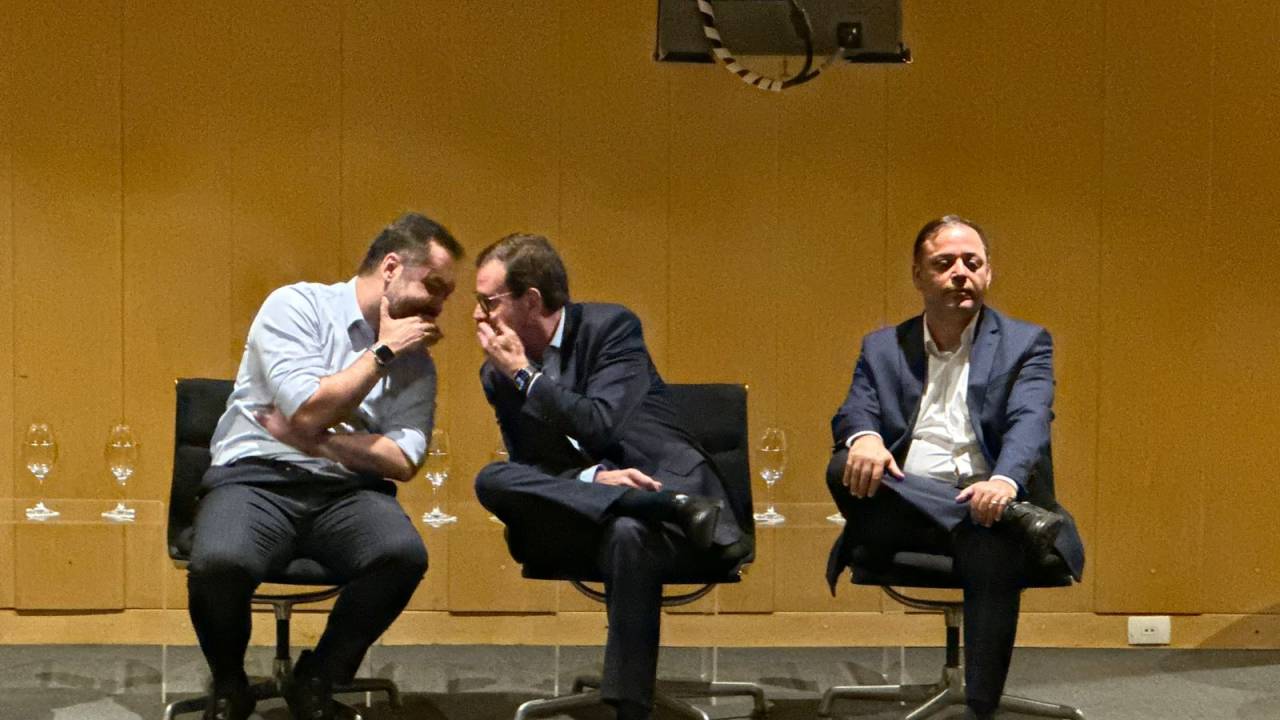 Cláudio Castro e Eduardo Paes cochicham ao pé do ouvido ao lado de Rodrigo Neves, em Niterói