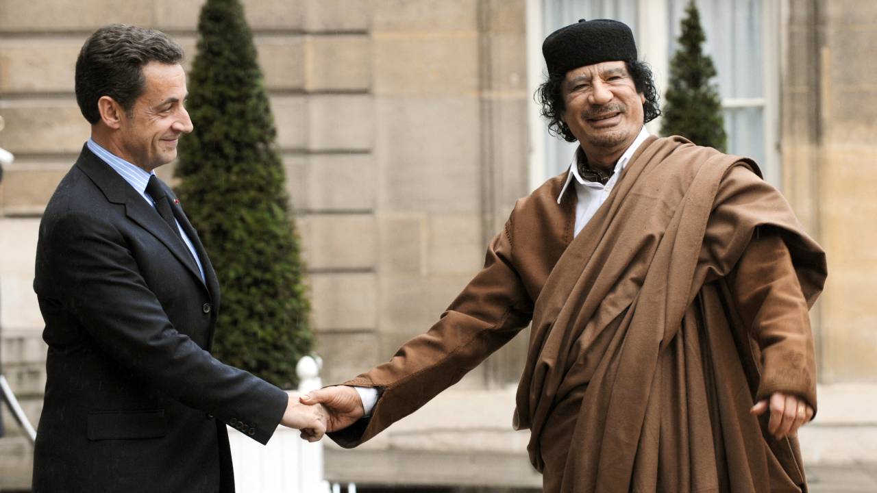 (FILES) Then French President Nicolas Sarkozy (L) welcomes Libyan leader Moamer Kadhafi at the French Elysee Palace in Paris on December 10, 2007. Former French president Nicolas Sarkozy, convicted twice in separate cases since leaving office, goes on trial on January 6, 2025, charged with accepting illegal campaign financing in an alleged pact with the late Libyan dictator Moamer Kadhafi. (Photo by Eric Feferberg / AFP)