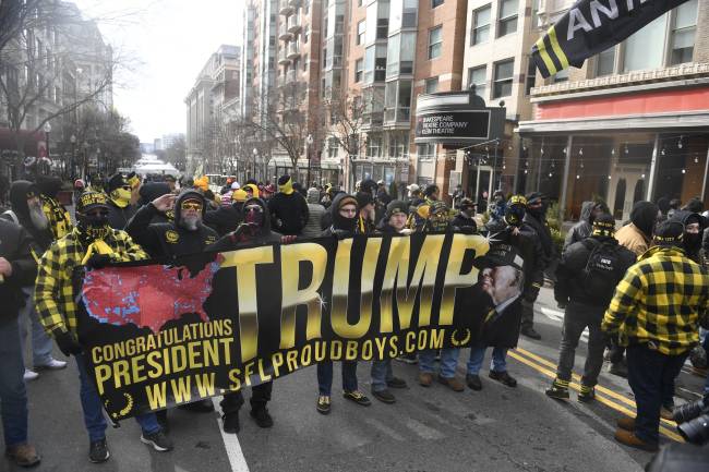 US-POLITICS-TRUMP-INAUGURATION Membros do Proud Boys seguram uma faixa em apoio ao presidente eleito dos EUA, Donald Trump, na rua em Washington, DC, em 20 de janeiro de 2025