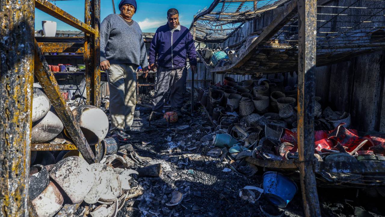 Palestinians inspect the damage at a shop on January 21, 2025, after it was burnt in reported overnight Israeli settler attacks in Jinsafot village east of Qalqiliya in the Israeli-occupied West Bank. The Palestinian Authority said on January 21 that US President Donald Trump's lifting of sanctions on Israeli settlers in the occupied West Bank "encourages them to commit more crimes against our people", pointing to recent atttacks by Israeli settlers throughout the West Bank that left 21 injured. (Photo by JAAFAR ASHTIYEH / AFP)