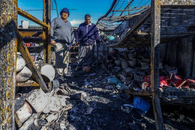 Palestinians inspect the damage at a shop on January 21, 2025, after it was burnt in reported overnight Israeli settler attacks in Jinsafot village east of Qalqiliya in the Israeli-occupied West Bank. The Palestinian Authority said on January 21 that US President Donald Trump's lifting of sanctions on Israeli settlers in the occupied West Bank 