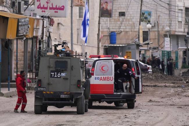 PALESTINIAN-ISRAEL-CONFLICT Israeli forces stop a Palestinian ambulance for a search as they block a road during a military raid in Jenin in the occupied West Bank, on January 22, 2025. A Palestinian official reported shooting and explosions in the flashpoint West Bank town of Jenin on January 22, as Israeli forces pressed a raid that the military described as a
