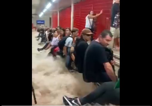 Passageiros tentam se proteger de alagamento em estação de metrô em São Paulo