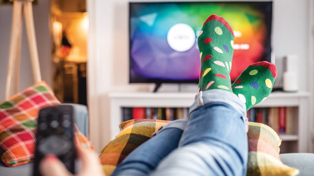 Woman watching tv at home. NO LAZER - Inércia: horas e horas no sofá trazem consequências ao organismo