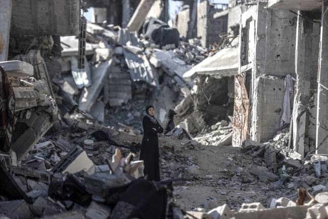 Palestinians continue to return to their homes as ceasefire comes into force in Gaza DEIR AL BALAH, GAZA - JANUARY 20: A woman stands among debris as displaced Palestinians continue to return their houses after the ceasefire and hostage-prisoner swap deal between Hamas and Israel at Bureij refugee camp in Deir al-Balah, Gaza on January 20, 2025. (Photo by Ali Jadallah/Anadolu via Getty Images)