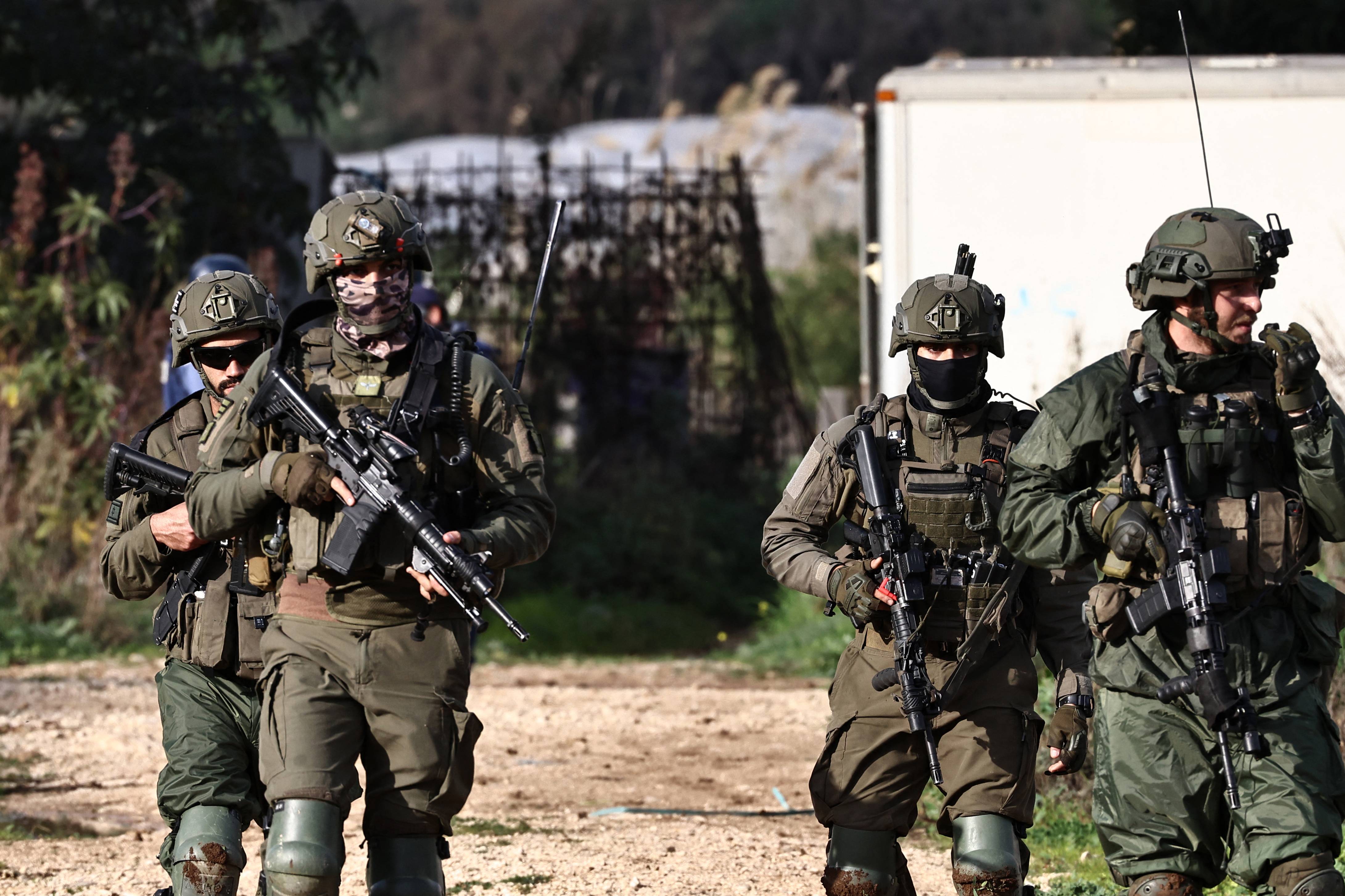 Israeli soldiers deploy at the entrance of the Tulkarem refugee camp, as the army conducts a raid in the occupied-West Bank city on February 5, 2025. Israeli military raids in two West Bank refugee camps have displaced nearly 5,500 Palestinian families since December, including an estimated 2,450 to 3,000 families from the Tulkarem refugee camp, local and UN officials said on February 4, amid escalating violence in the occupied territory. (Photo by Zain JAAFAR / AFP)