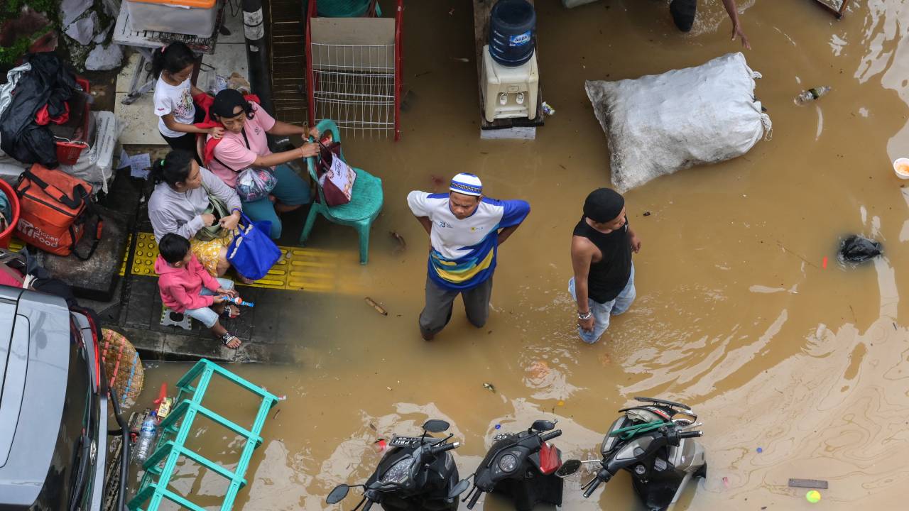 Pessoas cujas casas foram inundadas no distrito de Pasar Minggu, em Jacarta, em 4 de março de 2025.