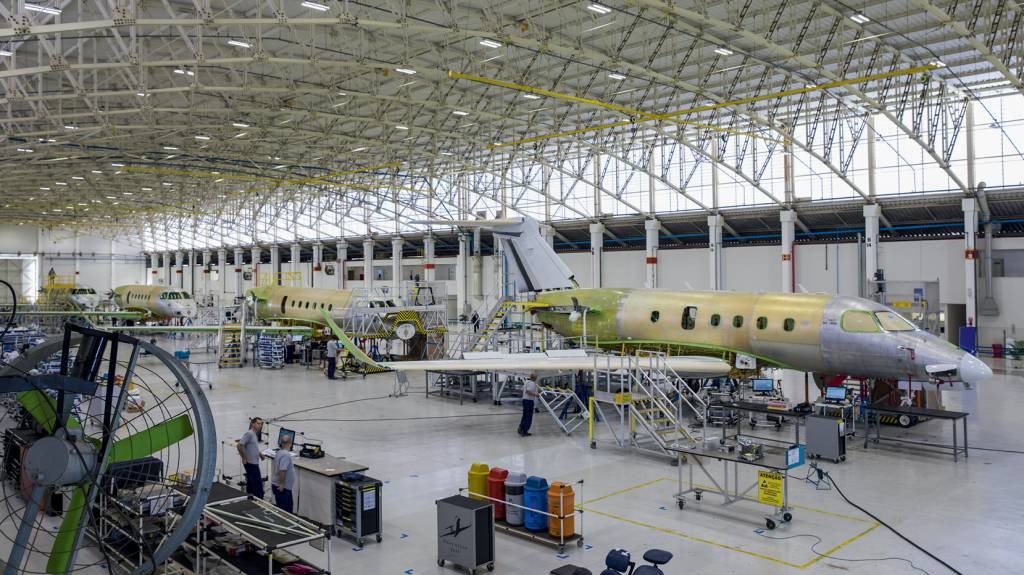Vista geral de montagens de jatos da Embraer PORTFÓLIO - Hangar da companhia: aviões comerciais, executivos e militares