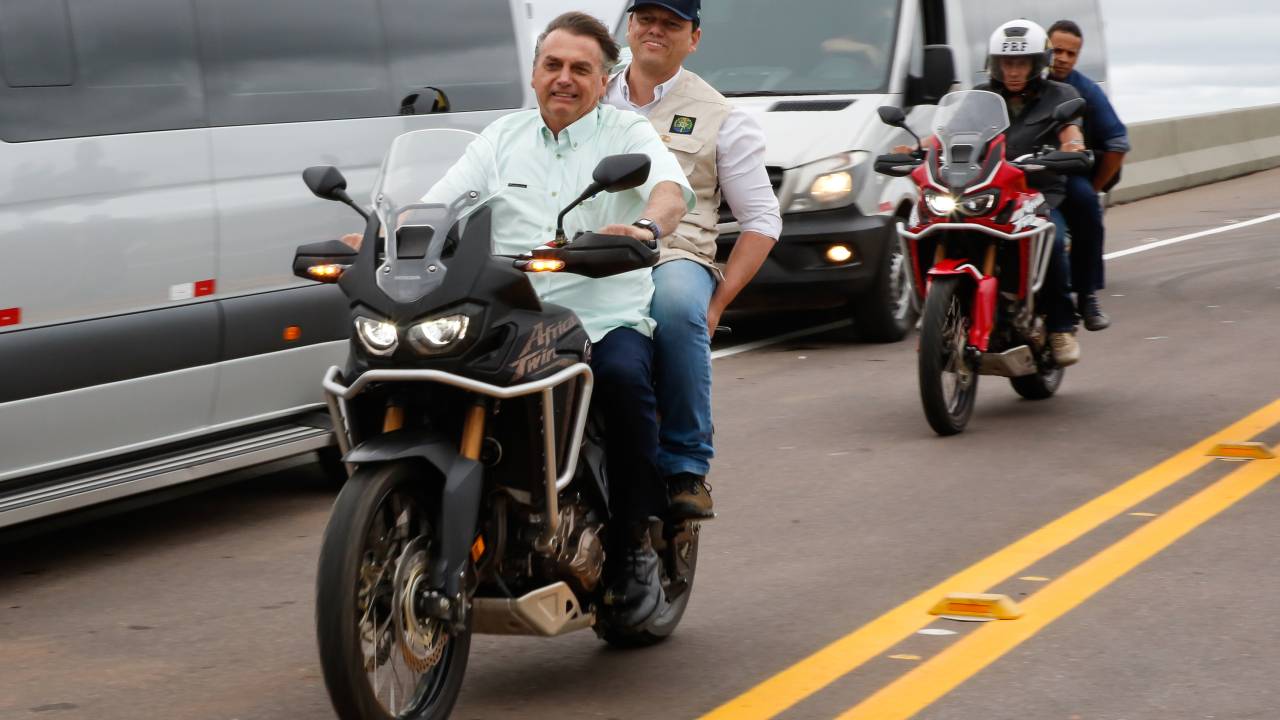 O então presidente Jair Bolsonaro e o então ministro da Infraestrutura, Tarcísio de Freitas, ambos sem capacete, andam de moto em ponte sobre o rio Madeira, na BR-364, em Rondônia, no dia 7 de maio de 2021