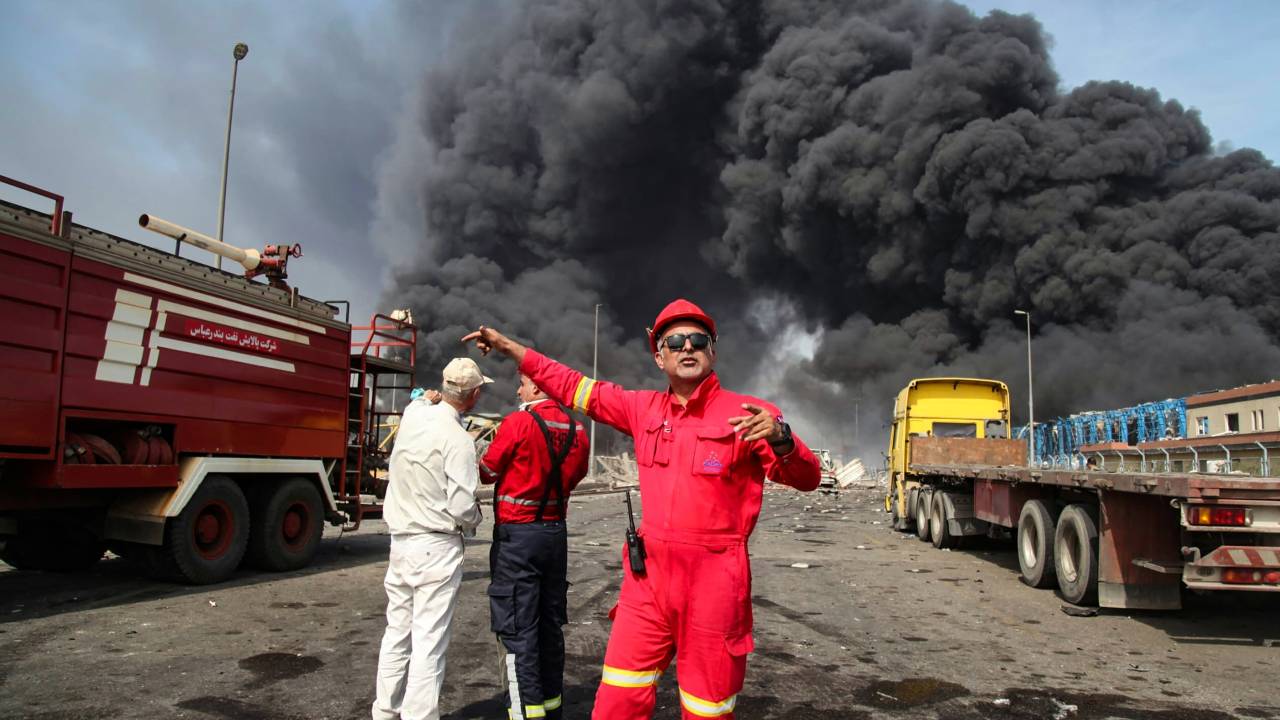 Thick, black smoke rises as rescuers arrive near the source of an explosion at the Shahid Rajaee port dock southwest of Bandar Abbas in the Iranian province of Hormozgan on April 26, 2025. Several containers exploded on April 26 at Iran's largest commercial port, authorities said, causing a major blast and fire, and leaving hundreds injured. Shahid Rajaee, more than 1,000 kilometres (620 miles) south of the capital, is the most advanced container port in Iran, according to the official IRNA news agency. (Photo by MOHAMMAD RASOLE MORADI / IRNA / AFP)