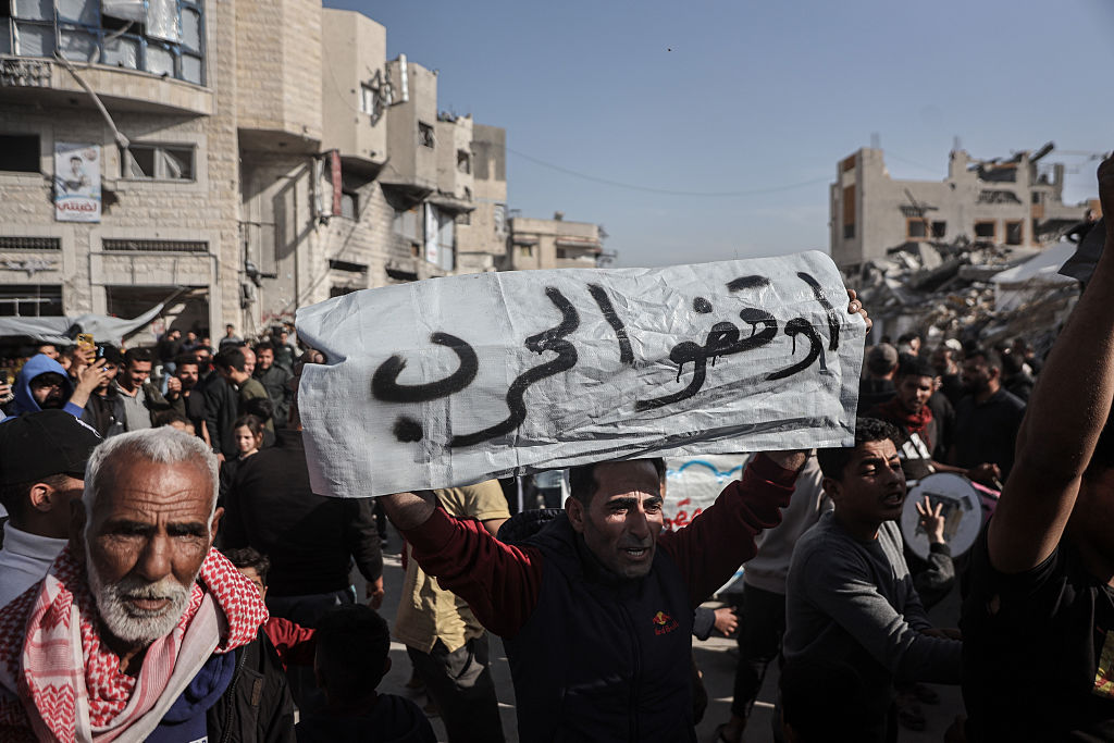 A Palestinian protester with a sign reading "Stop The War" during a demonstration against the Hamas militant group in Beit Lahiya, northern Gaza, on Wednesday, March 26, 2025. Protesters called on Hamas to relinquish control of Gaza and end the 18-month war with Israel that's killed tens of thousands of people. Photographer: Ahmad Salem/Bloomberg via Getty Images
