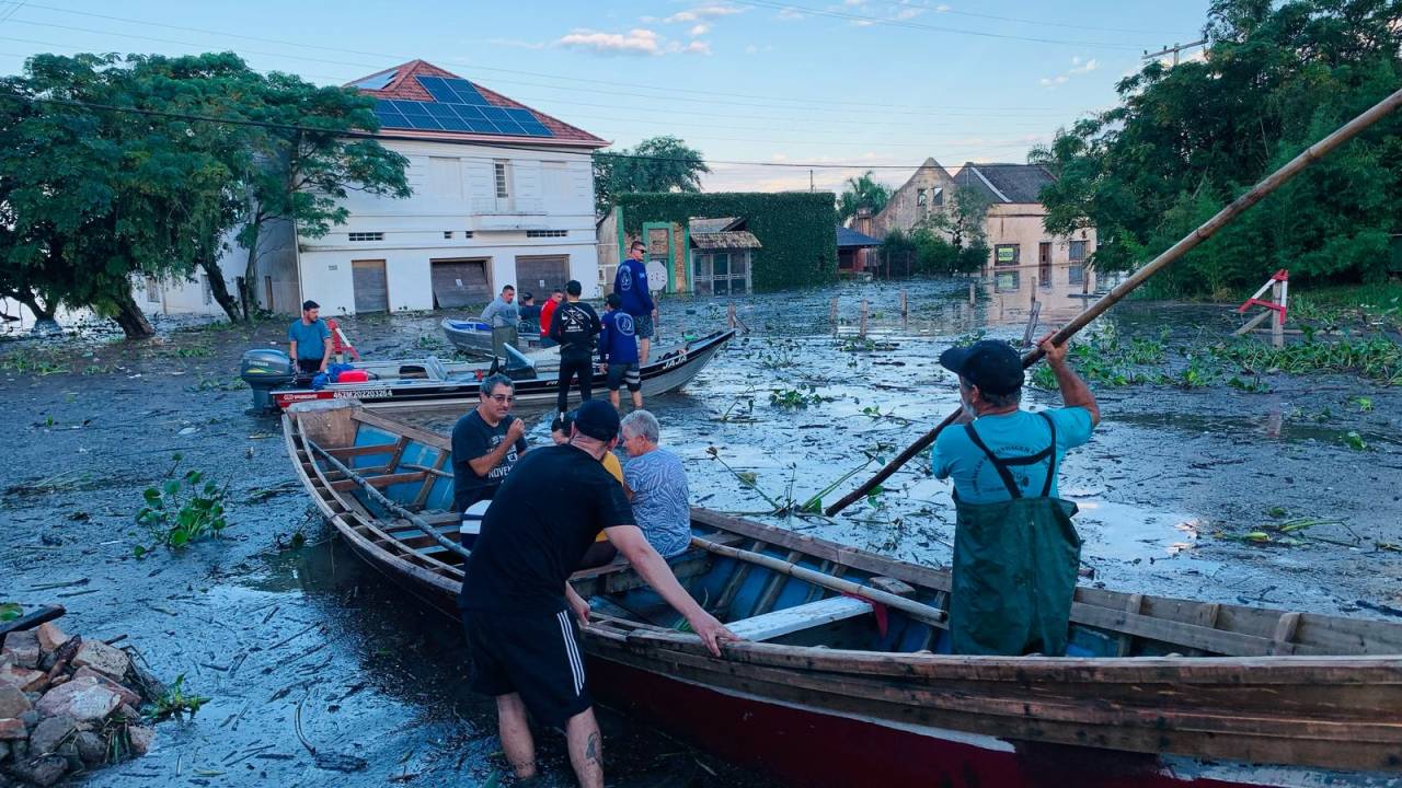 População circula de barco sobre as enchentes