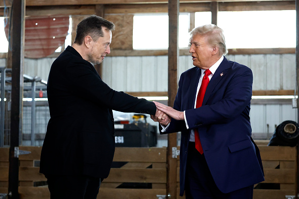 O bilionário Elon Musk (esquerda) aperta a mão do presidente dos EUA, Donald Trump.