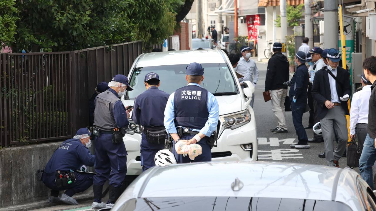 Police officers investigate the scene in Osaka's Nishinari district on May 1, 2025, after a man was arrested after allegedly ploughing his car into seven schoolchildren in a suspected deliberate attack, local media said. (Photo by JIJI PRESS / AFP) / Japan OUT
