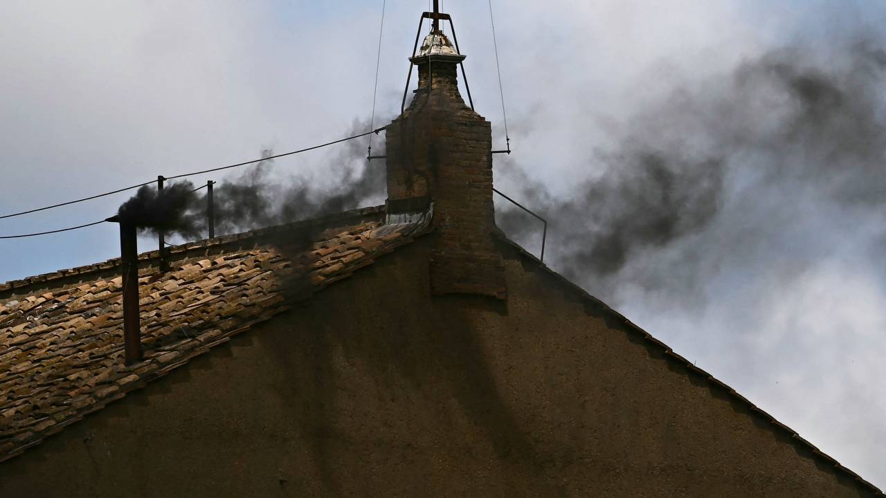 This photograph shows black smoke rising from the chimney of the Sistine Chapel signalling that cardinals failed to elect a new pope during their conclave in the Vatican on May 8, 2025. (Photo by Filippo MONTEFORTE / AFP)