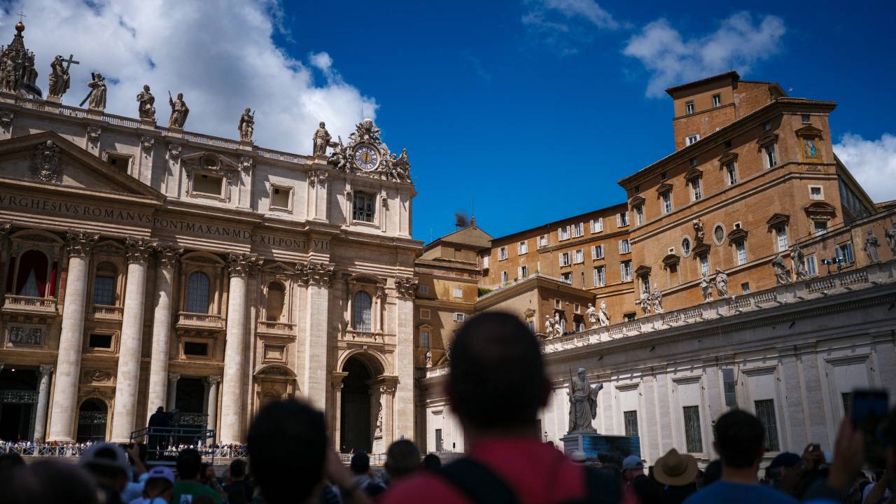 People stand on St Peter's Square after black smoke billowed from a chimney over the Sistine Chapel, on the second day of the conclave, in the Vatican on May 8, 2025. Black smoke billowed from a chimney over the Vatican's Sistine Chapel for a second day on May 8, as cardinals meeting in conclave once again failed to choose a new pope. Thousands of the faithful and curious were awaiting the smoke in St Peter's Square on the morning of the second day of secret voting by the 133 cardinal electors. (Photo by Dimitar DILKOFF / AFP)