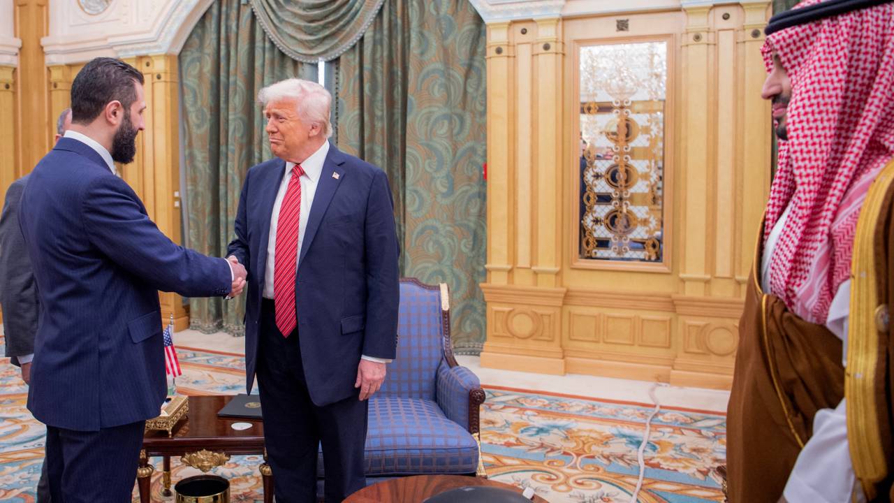A handout picture provided by the Saudi Royal Palace shows Saudi Crown Prince Mohammed bin Salman (R) watching as US President Donald Trump (C) shakes hands with Syria's interim president Ahmed al-Sharaa in Riyadh on May 14, 2025. Trump became the first US president in 25 years to meet a Syrian leader on May 14, after he offered sanctions relief in hopes of offering a new path to the war-battered country. (Photo by Bandar AL-JALOUD / Saudi Royal Palace / AFP) / RESTRICTED TO EDITORIAL USE - MANDATORY CREDIT "AFP PHOTO / SAUDI ROYAL PALACE / BANDAR AL-JALOUD" - NO MARKETING - NO ADVERTISING CAMPAIGNS - DISTRIBUTED AS A SERVICE TO CLIENTS