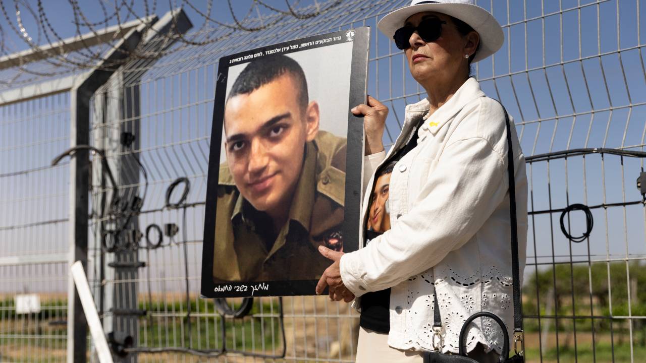 Varda Ben Baruch segura uma foto de seu neto, Edan Alexander, durante uma manifestação de famílias de reféns em Nir Oz, em Israel. 20/04/2025