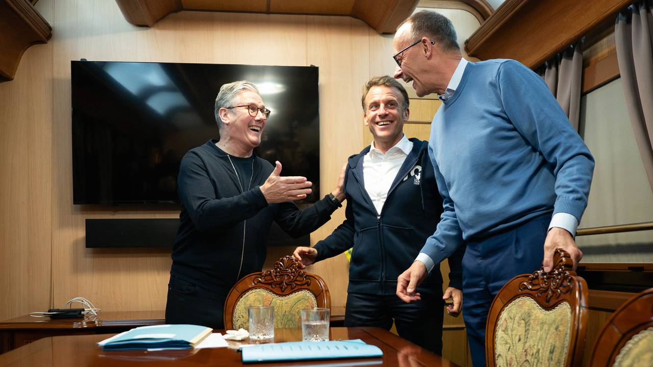 presidente da França, Emmanuel Macron (no centro); o chanceler alemão, Friedrich Merz (à dir., de azul); e o primeiro-ministro britânico, Keir Starmer