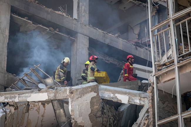 Iranian firefighters work at the scene of a destroyed residential building due to Israeli attacks in Tehran, Iran, on June 13, 2025. (Photo by Morteza Nikoubazl/NurPhoto via Getty Images)