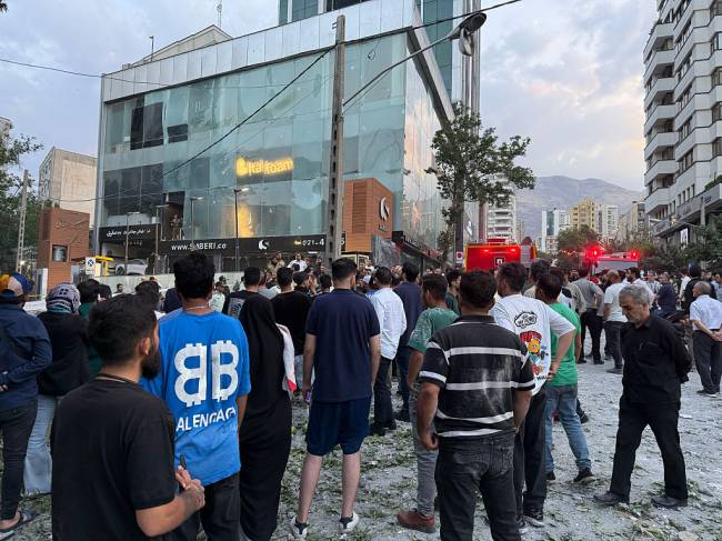 TEHRAN, IRAN - JUNE 13: People look over the aftermath of a massive Israeli airstrike that destroyed multiple buildings in the Kamranieh and Farmanieh neighborhoods on June 13, 2025 in Tehran, Iran. (Photo by Contributor#699095/Getty Images)