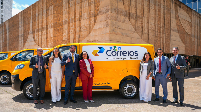 Fabiano Silva, presidente dos Correios (de gravata amarela), posa com representantes da Infracommerce em frente a van com o logo do marketplace da estatal
