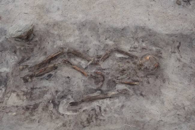 Esqueleto da mulher viking encontrado em Senja, no norte da Noruega; ela foi enterrada em um barco com objetos de prestígio e um cachorro aos pés