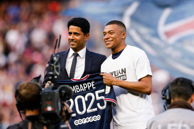 Kylian Mbappé no PSG PARIS, FRANCE - MAY 21: Kylian Mbappe of Paris Saint Germain (R) poses for photos with PSG president Nasser Al-Khelaifi (L) after renewed his contract until 2025 during the Ligue 1 Uber Eats match between Paris Saint Germain and FC Metz at Parc des Princes on May 21, 2022 in Paris, France. (Photo by Antonio Borga/Eurasia Sport Images/Getty Images)