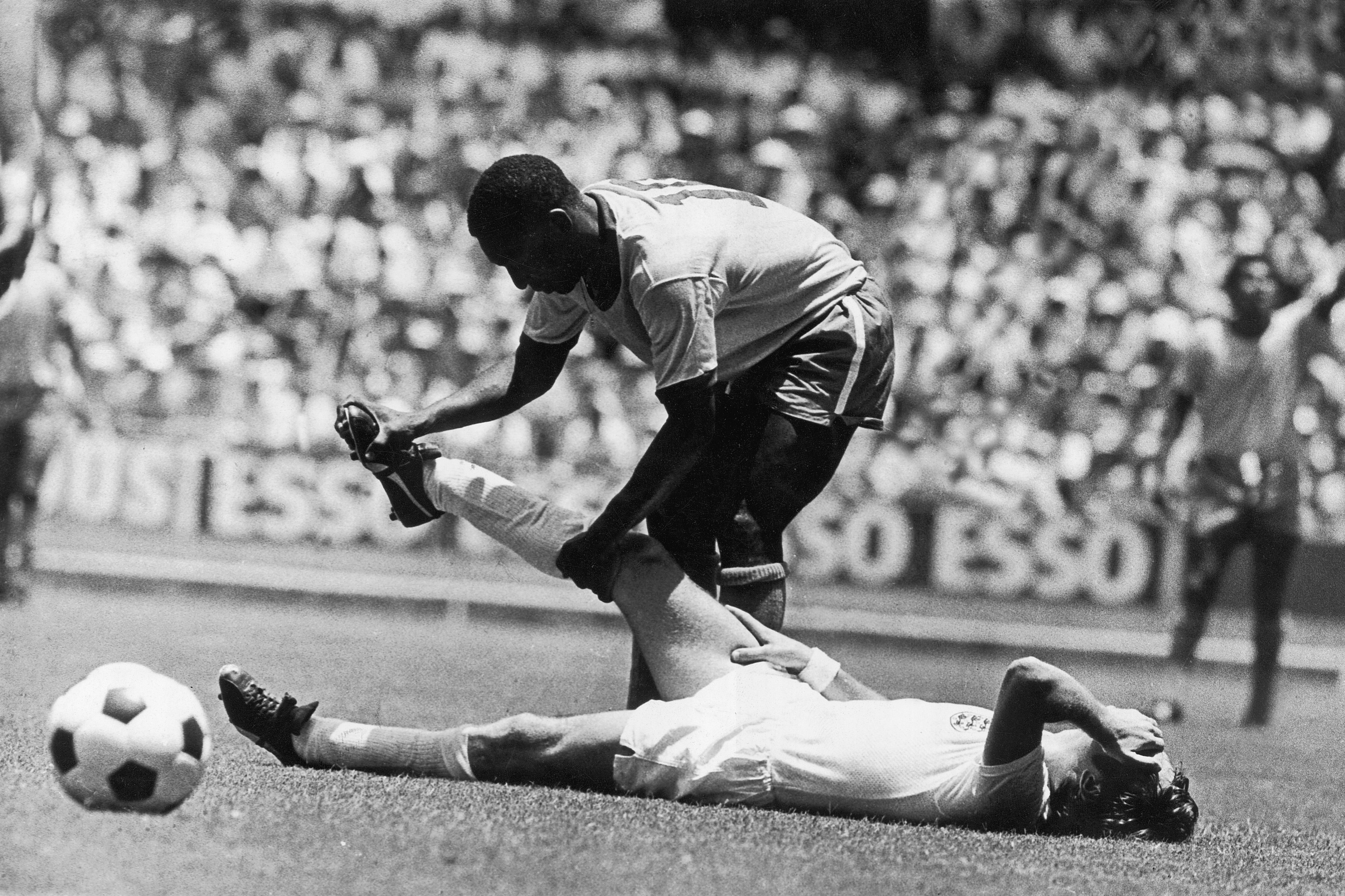 Pel&eacute; ajudando Bobby Moore, da Inglaterra, na Copa do Mundo de 1970