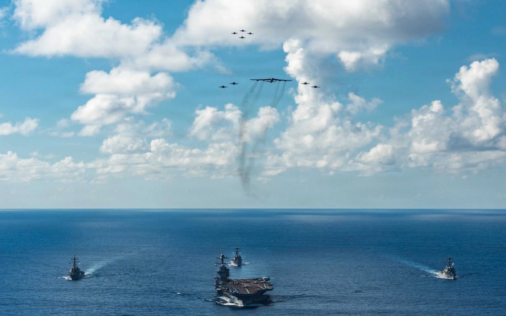 O Grupo de Ataque do Porta-Aviões Gerald R. Ford da Marinha dos EUA, incluindo o navio-almirante USS Gerald R. Ford (CVN 78), à frente, o USS Winston S. Churchill (DDG 81), à direita, o USS Mahan (DDG 72), à esquerda, o USS Bainbridge (DDG 96) e os caças F/A-18E/F Super Hornets embarcados. 13/11/2025
